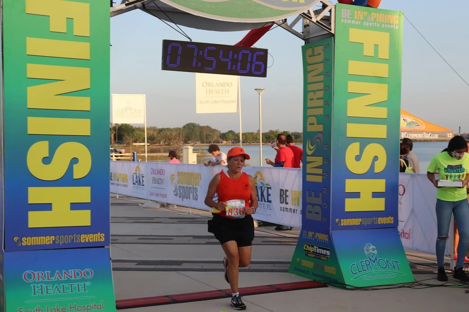 A runner crosses the finish line of a 5K race at Victory Pointe on the Clermont lakefront.