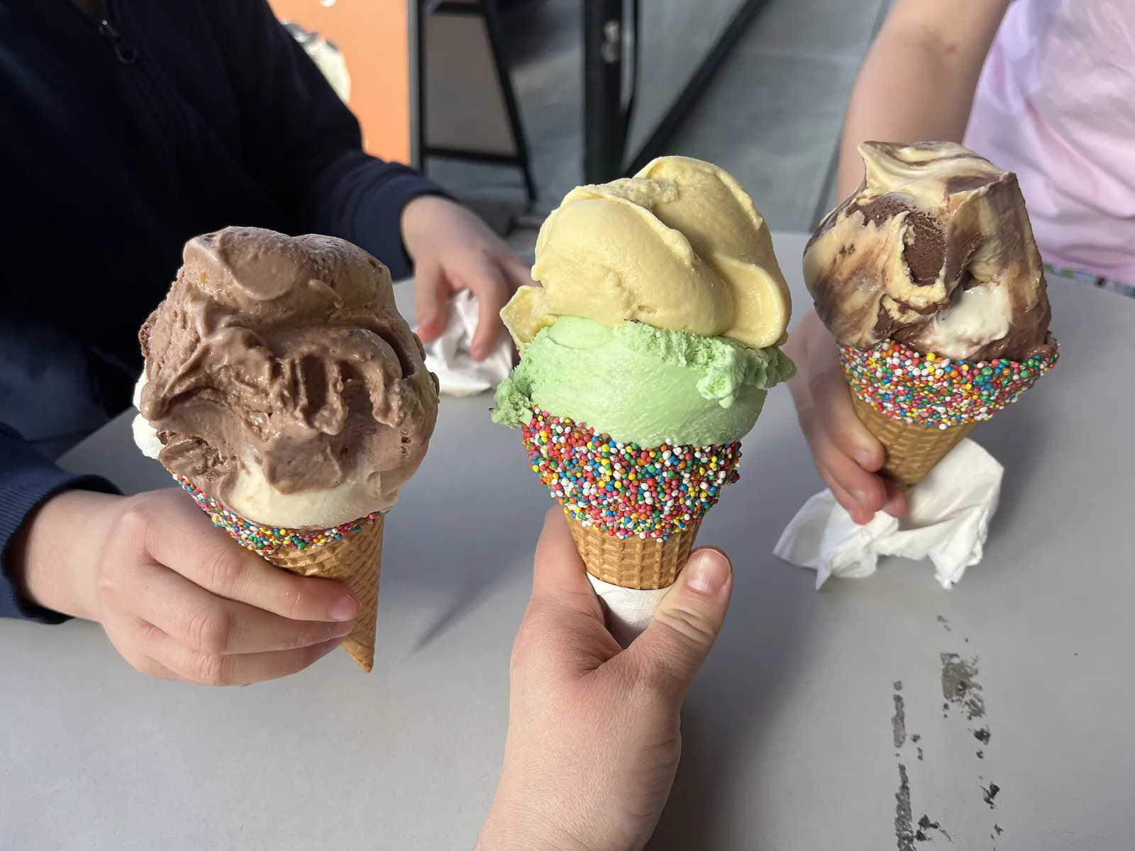 Three ice cream cones with sprinkles. The photo was not taken at a Clermont shop.